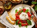 Pyszny **burrata przepis** na talerzu: kremowy ser, pomidory, bazylia i chrupiące pieczywo. Idealna propozycja na lekki posiłek.