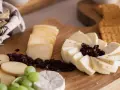 Deska serów z winogronami, suszoną żurawiną i pieczywem. Idealna na spotkanie z przyjaciółmi.