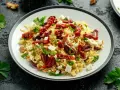 Pyszna sałatka z makaronem orzo, z suszonymi pomidorami, oliwkami, fetą i natką pietruszki. Idealna na lekki posiłek.