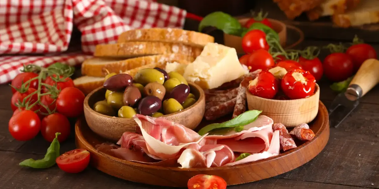 Antipasti co to? Talerz pełen smakołyków: oliwki, pomidorki, wędliny, ser i pieczywo. Idealne na przystawkę.