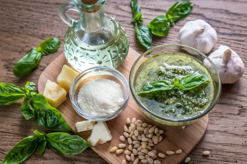 Składniki do przygotowania pesto: świeża bazylia, orzeszki piniowe, czosnek, parmezan, oliwa.